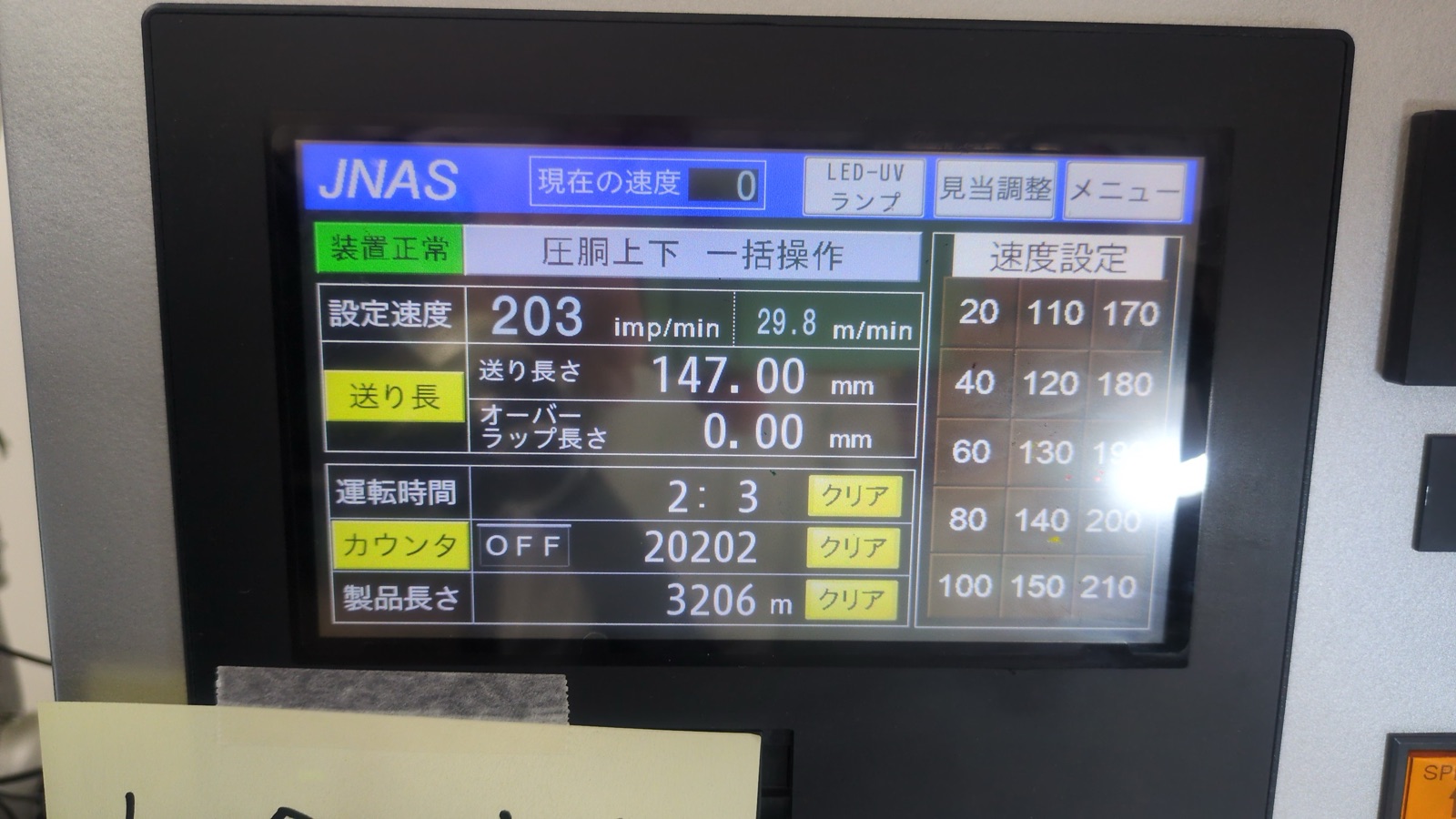 印刷機の操作盤。速度や送り長さの数値が表示されている