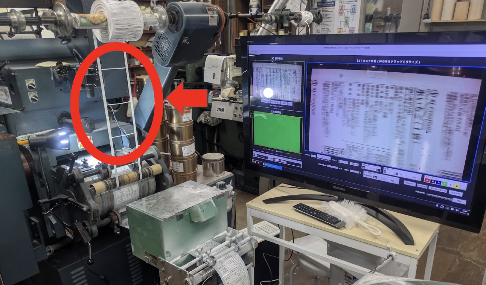 印刷機を流れるラベルの抜けカス。赤丸で囲まれている