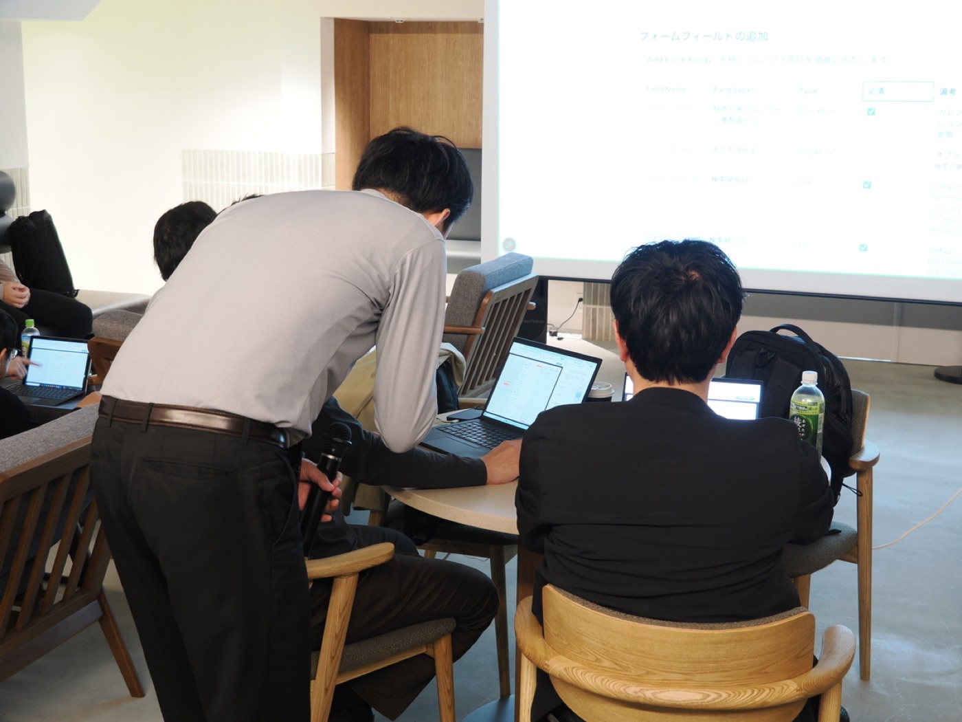 受講者のノートパソコンを覗き込みながら操作を教えている様子